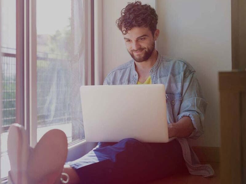 Person using a laptop on a window sill